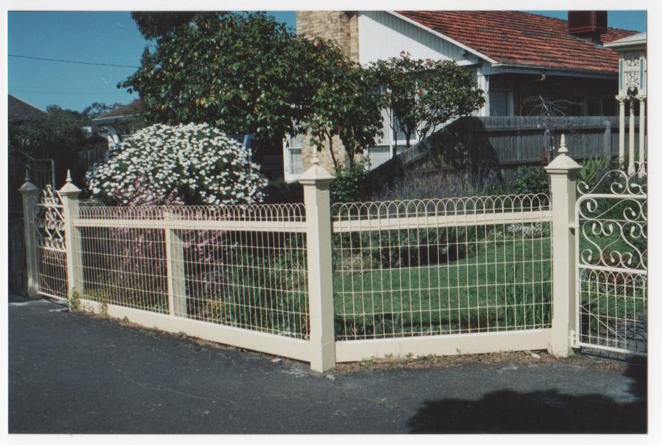 Woven-wire fence with gate and scroll detail on a street frontage