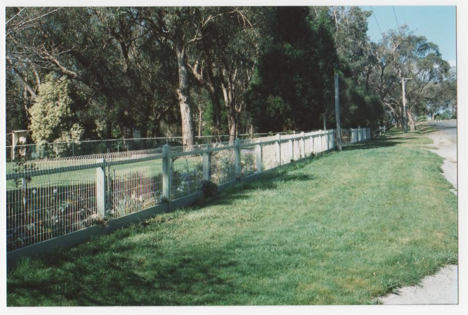 Wire mesh fence bordering a footpath and lawn