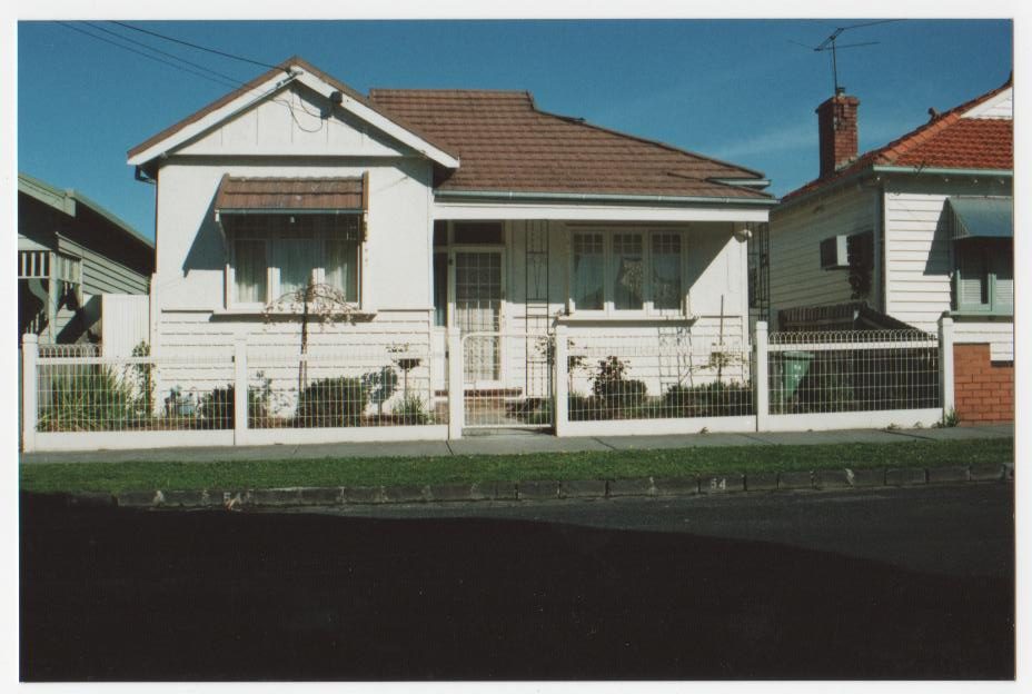 White fence and gate in front of a home