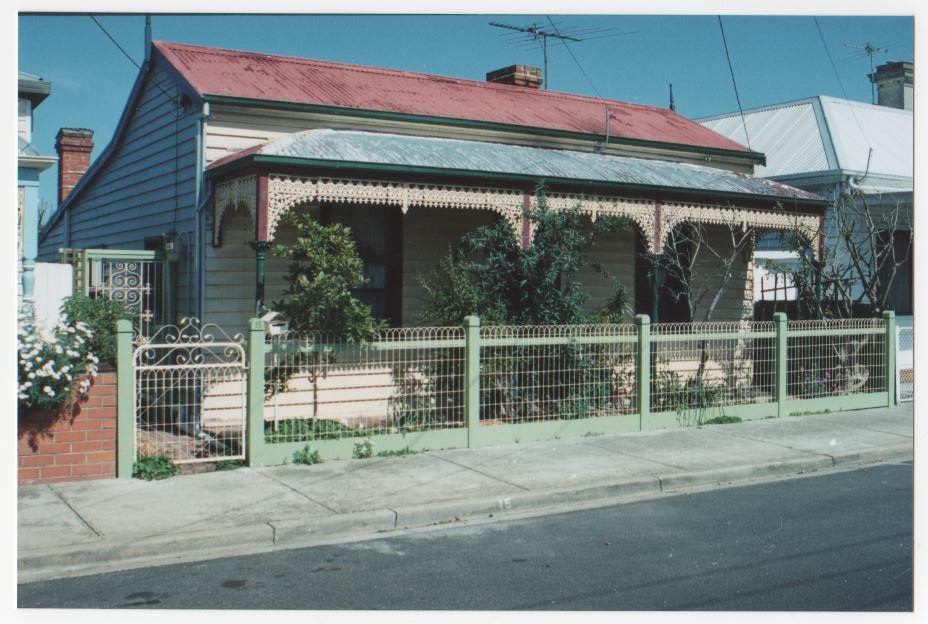 Fence and gate in front of a home with tiled roof